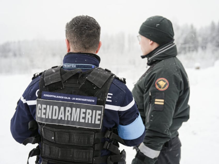 A frontex official and a Finnish border guard stand near the closed Vaalimaa border station between Finland and Russia, on December 7, 2023. The Nordic country, which shares a 1,340-kilometre (830-mile) border with Russia, has seen a surge in undocumented migrants seek asylum on its border with Russia in November …