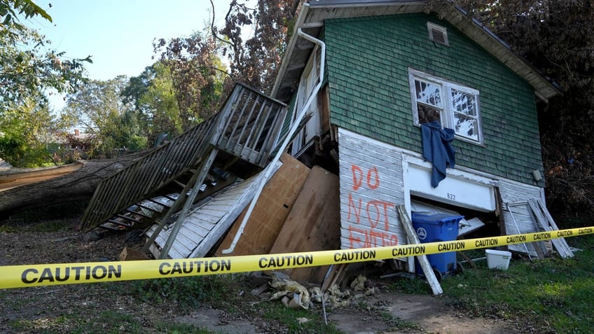 A house sits damaged on Oct 8, 2024, in Asheville, NC, during the aftermath of flooding caused by the remnants of Hurricane Helene. Helene's swath of destruction brought historic rainfall, flooding, power outages and 140-mile-an-hour winds across the Southeast. North Carolina the bore the brunt of damage, with vast swaths of cities like Asheville underwater, residents trapped in their homes with no lights or food and few functioning roads for rescue workers to help them.