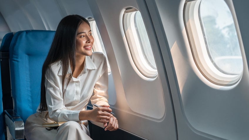 Woman looking out the window on an airplane