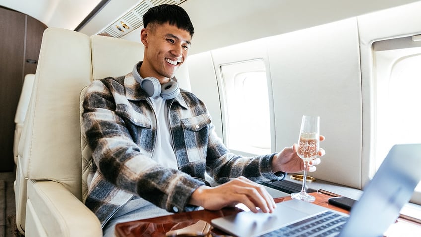 man drinking champagne on flight