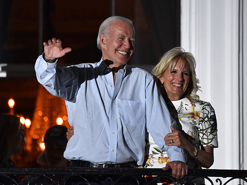 US President Joe Biden (L) and US First Lady Jill Biden wave from a balcony of the White House duri