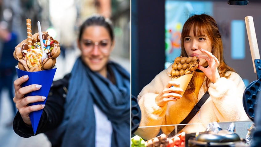 A woman, left, holds a bubble waffle with ice cream and candies on a blue paper cone. Another woman, right, eats a dessert egg waffle.