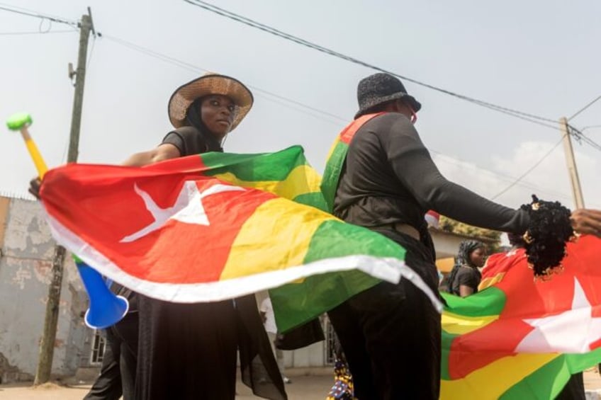 A Togolese woman dressed in black and holding the national flag in the capital Lome during