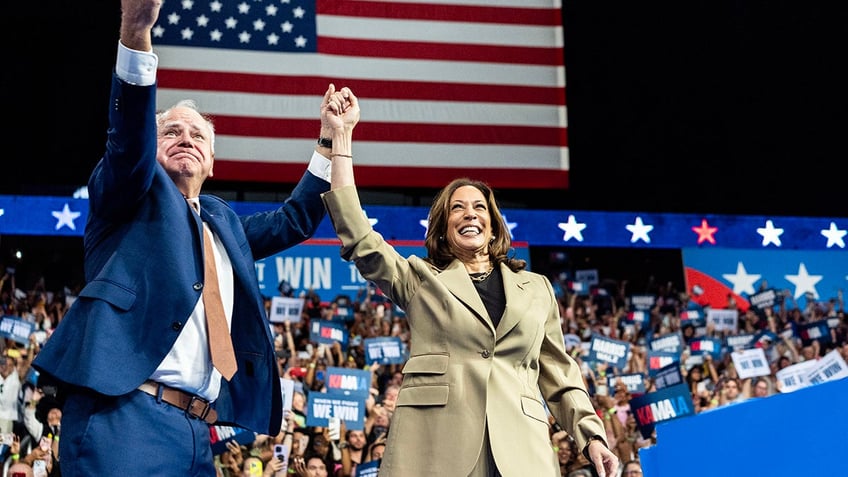 Harris and Walz with arms raised at rally