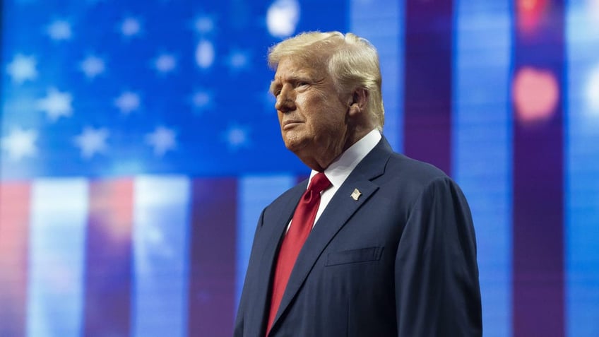 Trump closeup shot on stage, US flag behind him