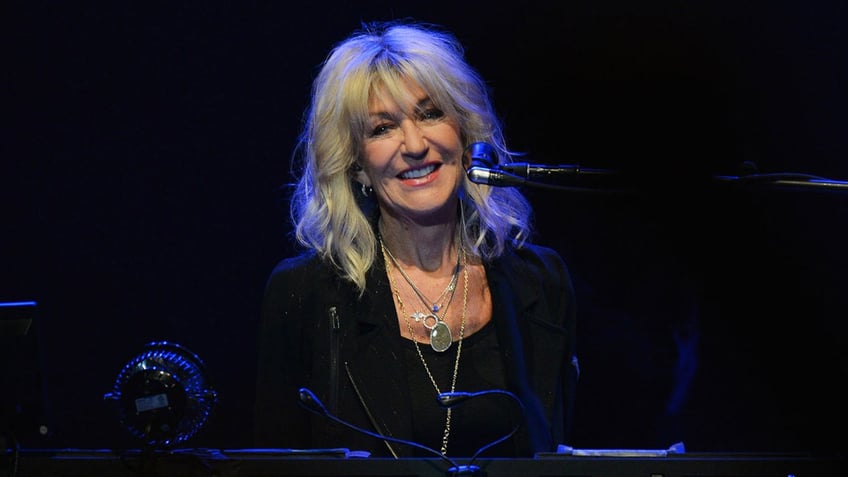 Christine McVie sings at her keyboard during concert