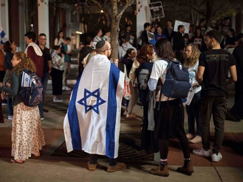 Jewish Rutgers University's students and members of the community gather holding plac