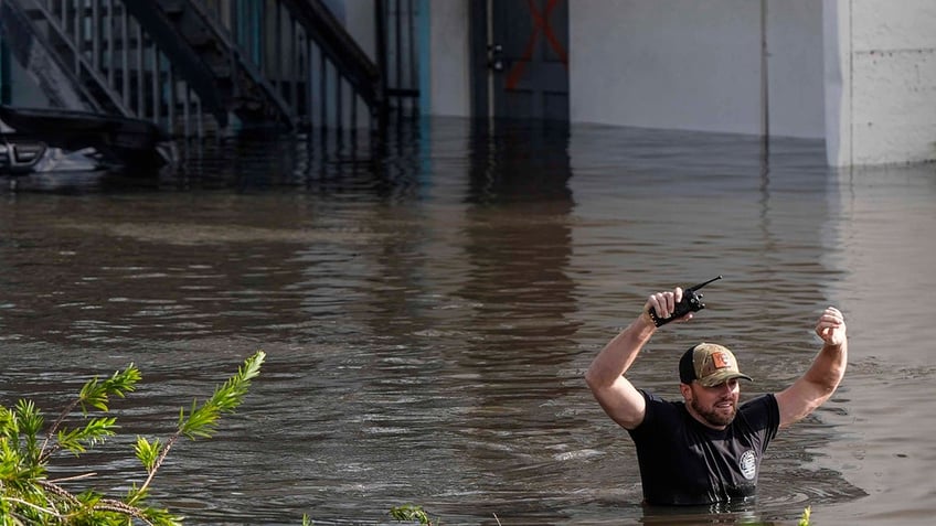 A water rescue team member walks through flood waters at an apartment complex in the aftermath of Hurricane Milton