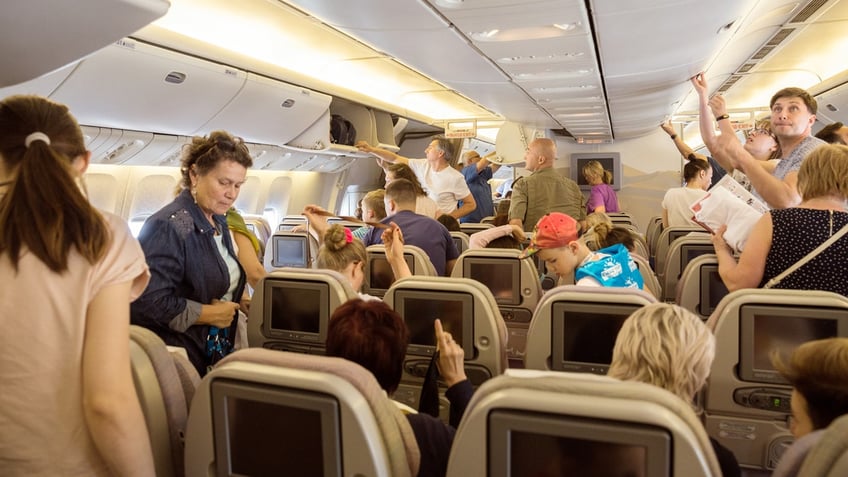 Airplane passengers are pictured standing up on a flight