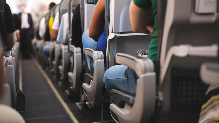 Travelers sitting in airplane seats.