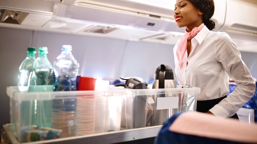 The cabin crew pushing the cart on aisle to serve the customers