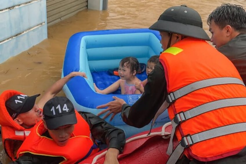 Rescuers help children escape flood waters in Vietnam's northern Ha Giang province on June