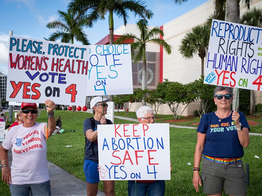 People hold up signs during a pro-abortion rights rally on the second anniversary of the S