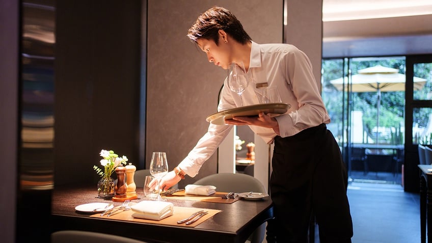 waiter placing tableware