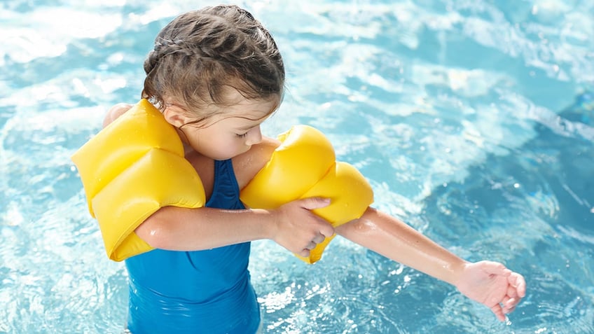 little girl wearing arm floaties