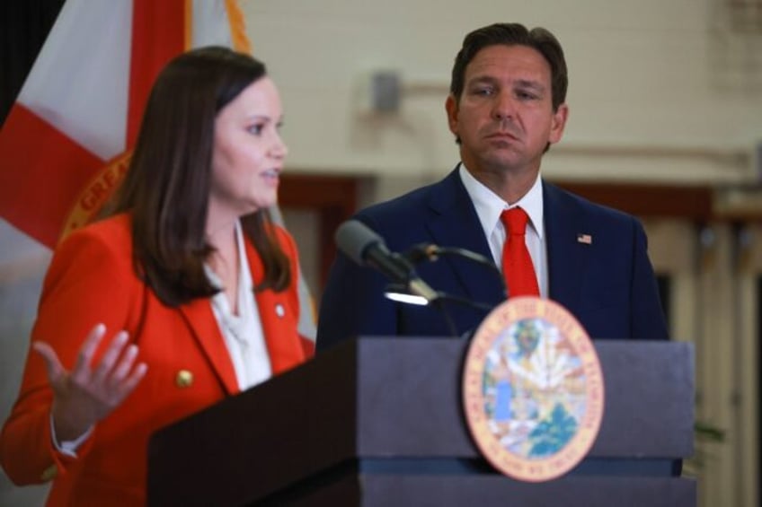 Florida Governor Ron DeSantis listens as state Attorney General Ashley Moody speaks about