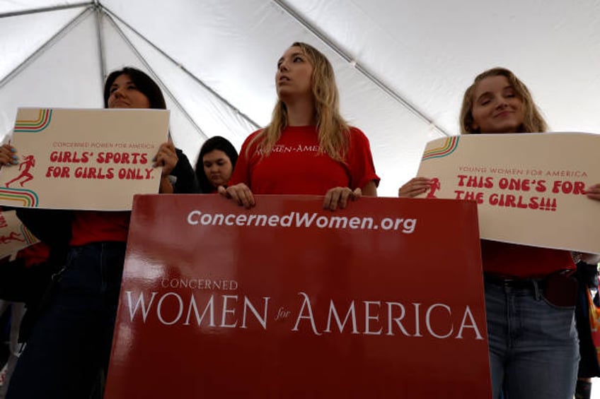 Demonstrators listen to the speaking program during an "Our Bodies, Our Sports" rally for the 50th anniversary of Title IX at Freedom Plaza on June...