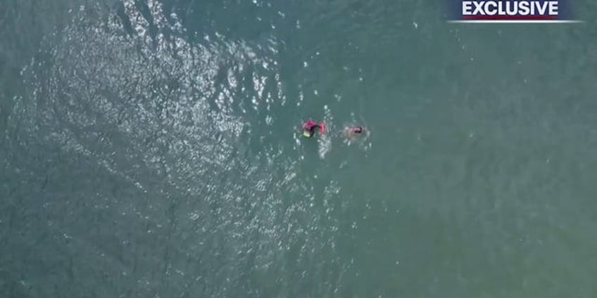 florida lifeguards form human chain to rescue boogie boarder drone video shows