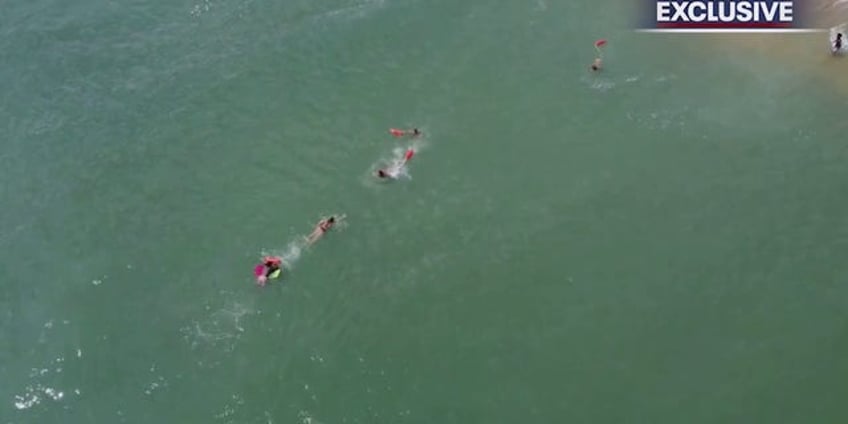 florida lifeguards form human chain to rescue boogie boarder drone video shows