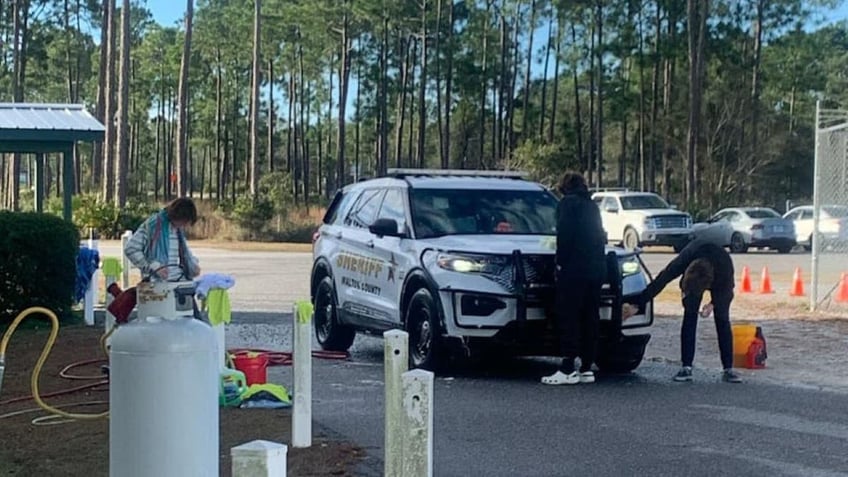 Teenagers cleaning up police cruiser