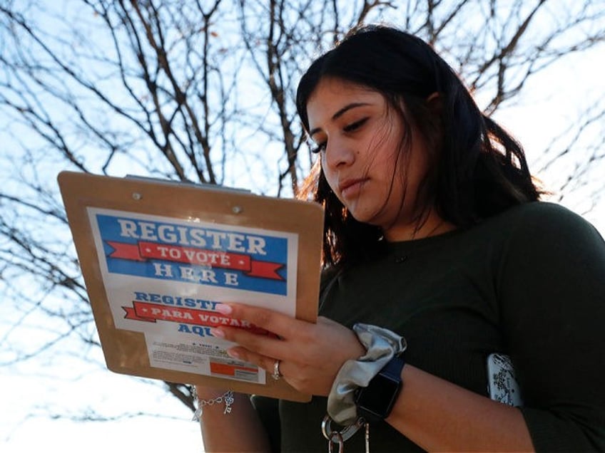 Karina Shumate, 21, a college student studying stenography, fills out a voter registration