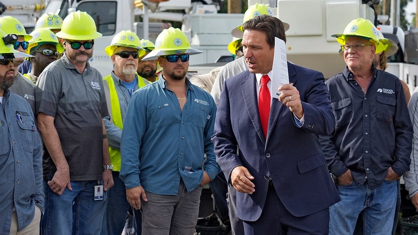 Florida Gov. Ron DeSantis, second from right, speaks to linemen before a news conference on Sept. 25 prior to Helene impacting the state. 