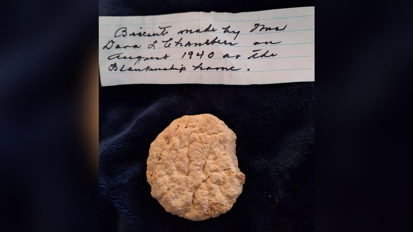 A picture of a frozen biscuit and the note that came with it. The note states the biscuit was made in 1940.