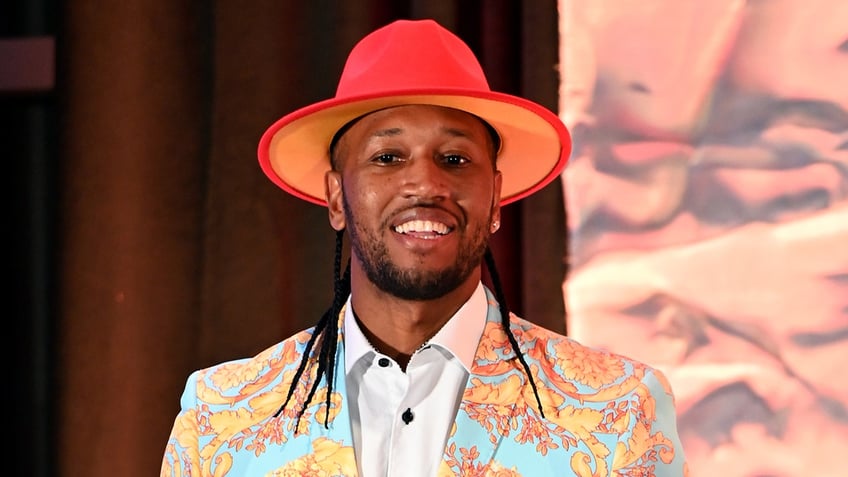 Chef Darnell Ferguson wears orange hat and colorful blazer