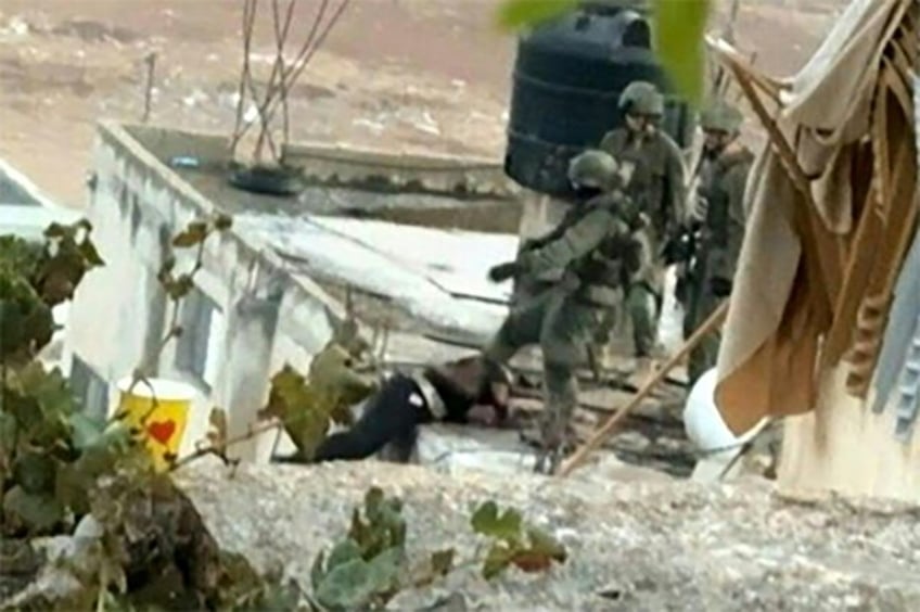 An image grab taken from an AFPTV video shows an Israeli soldier pushing an apparently dea