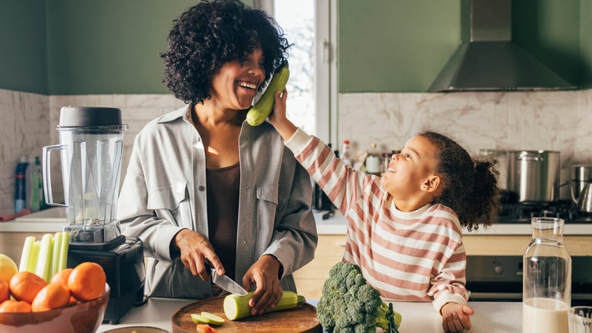 a mother and daughter prep vegetables in the kitchen