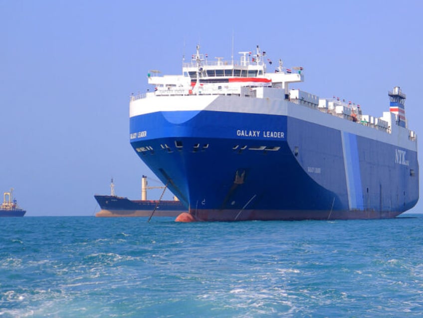 A picture taken during an organised tour by Yemen's Huthi rebels on November 22, 2023 shows the Galaxy Leader cargo ship (R), seized by Huthi fighters two days earlier, approaching the port in the Red Sea off Yemen's province of Hodeida. The Bahamas-flagged, British-owned Galaxy Leader, operated by a Japanese …