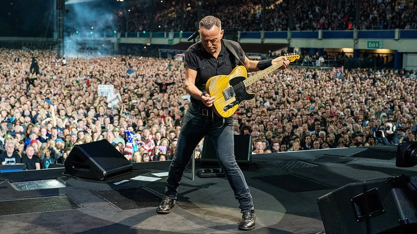 Bruce Springsteen playing guitar on stage