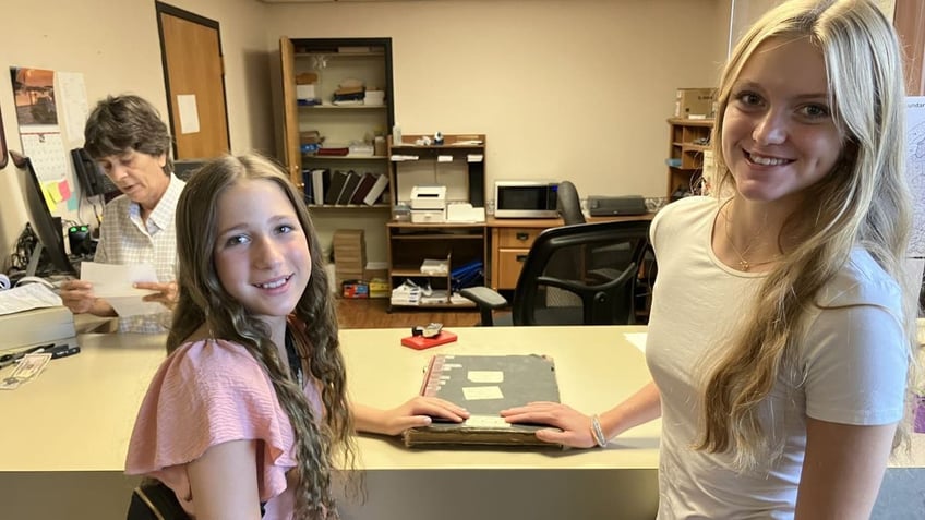 Girls smiling with old book