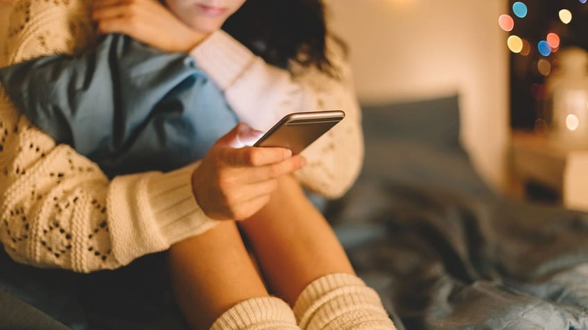 Girl texting on smartphone at home