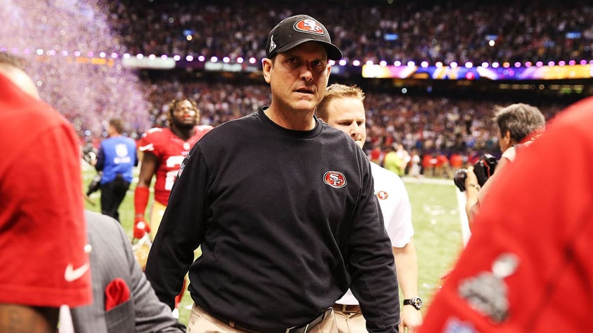 Jim Harbaugh walks off the football field