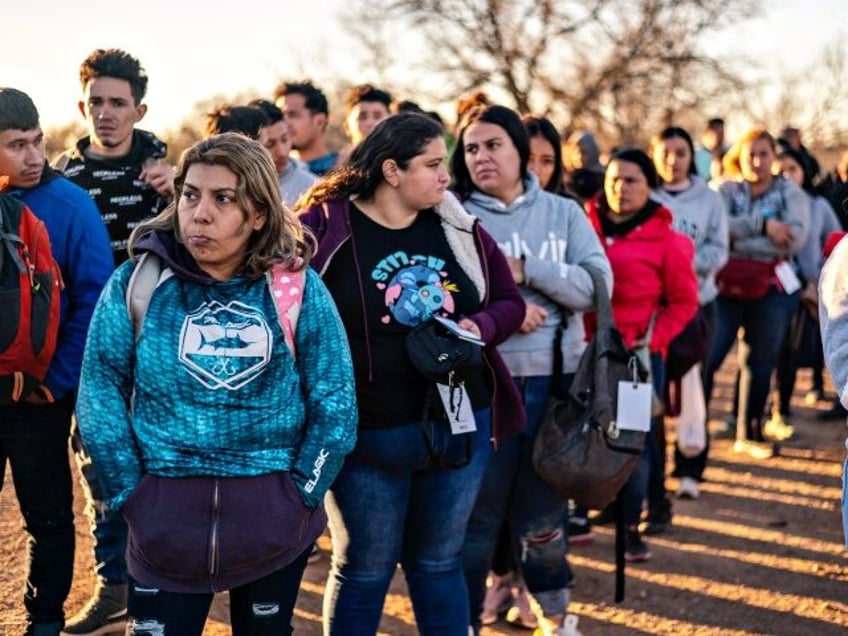 A group of migrants are processed by Border Patrol after crossing the river illegally near