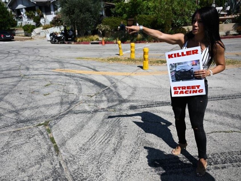 A local resident and protester with Street Racing Kills points to tire skid marks from dri