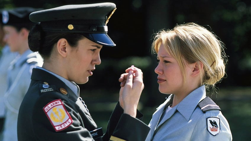 Christy Carlson Romano as Jennifer Stone in a cadet uniform stands across Hilary Duff as Cadet Kelly in the TV movie, "Cadet Kelly"