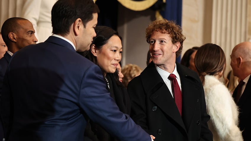 Senator Marco Rubio shakes hands with Facebook CEO Mark Zuckerberg who stands next to his wife Priscilla Chan