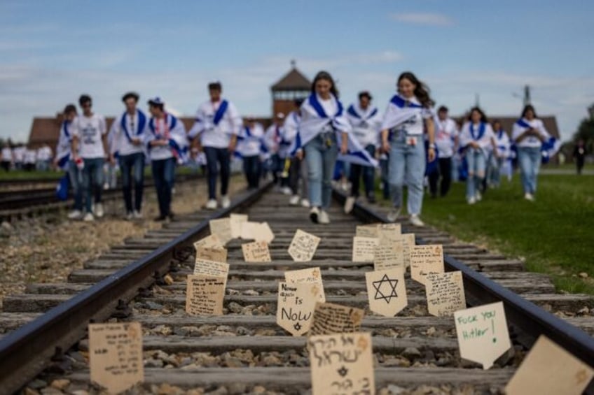 Wooden plaques with messages and prayers placed on the railway to the former Auschwitz-Bir