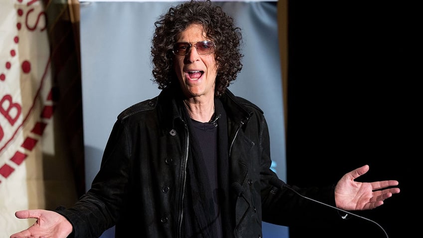 Howard Stern in mid-sentence wearing all black