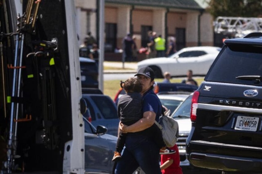 Parents arrive to pick up their children after the shooting took place at Apalachee High S