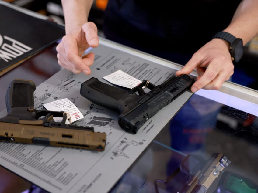 Brandon Wexler helps a customer shop for a handgun at his WEX Gunworks store on January 31
