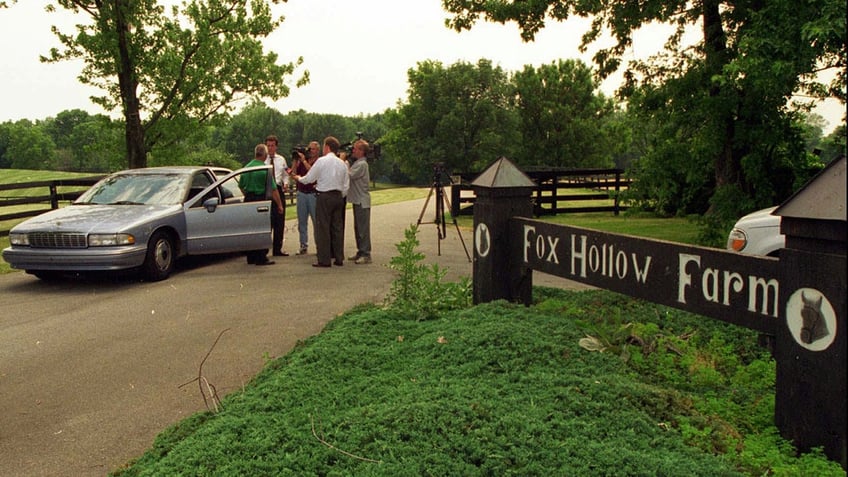 Investigators outside a car parked at Fox Hollow Farm