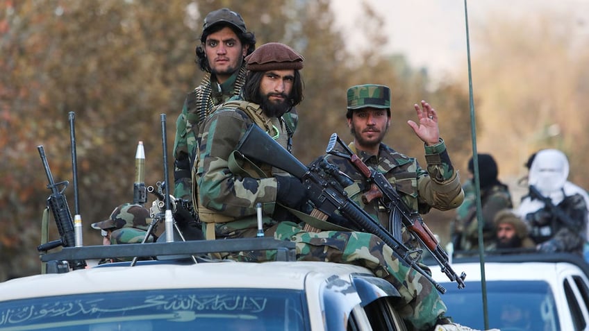 Members of the Taliban sit on a military vehicle during a Taliban military parade in Kabul, Afghanistan, in November 2021.