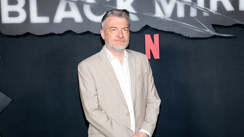 Charlie Brooker in front of Black Mirror signage