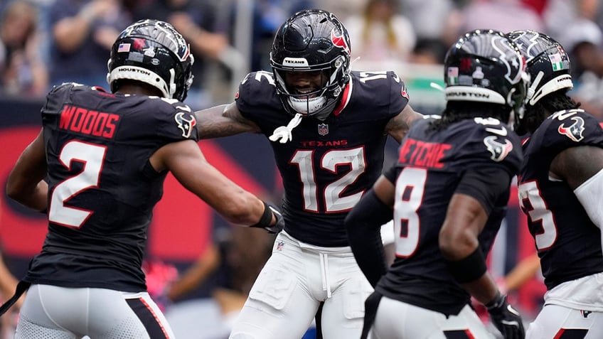 Nico Collins celebrates with Robert Woods