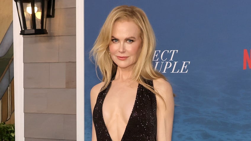 Nicole Kidman in a plunging black dress with little sparkles looks sultry on the carpet