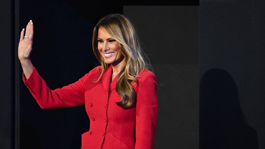 Melania Trump in red suit waving