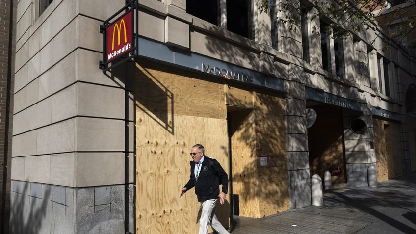 man walks by boarded up McDonald's in Washington, D.C. 